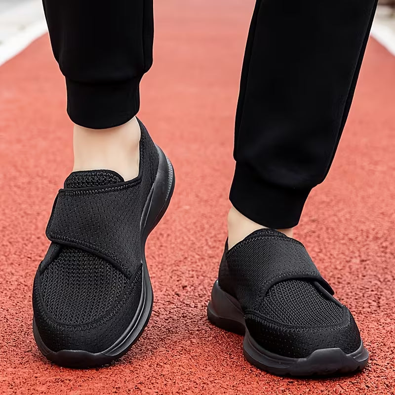 Black CloudStride shoes worn on a running track, showing the wide front and strap